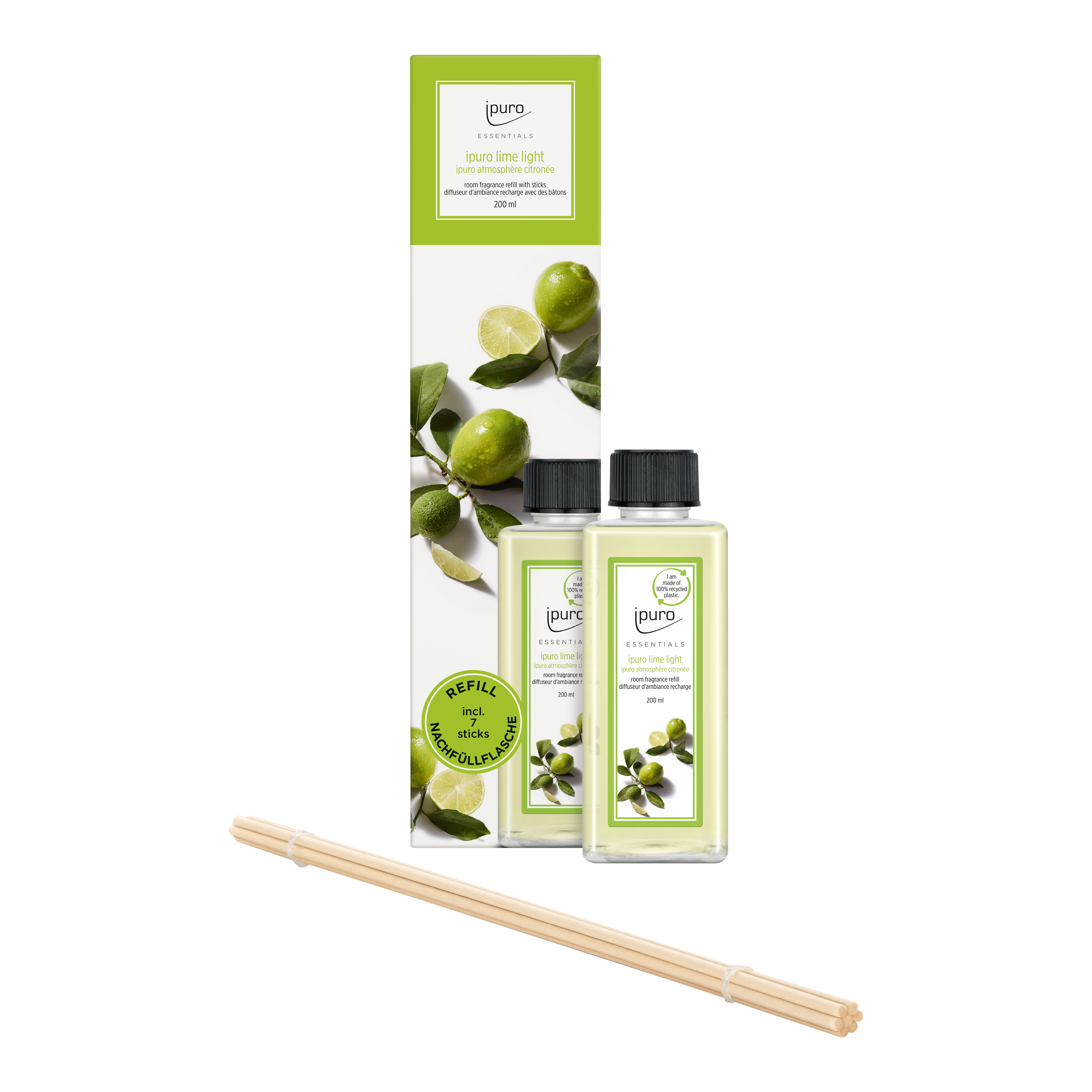 Zwei klare Flaschen ESSENTIALS ipuro lime light Raumduft-Nachfüller von ipuro, mit einer Schachtel mit Limetten und Blättern. Mehrere hölzerne Diffusorstäbchen in der Front - ideal für einen Zitronengras-Duft, der für gute Laune sorgt.