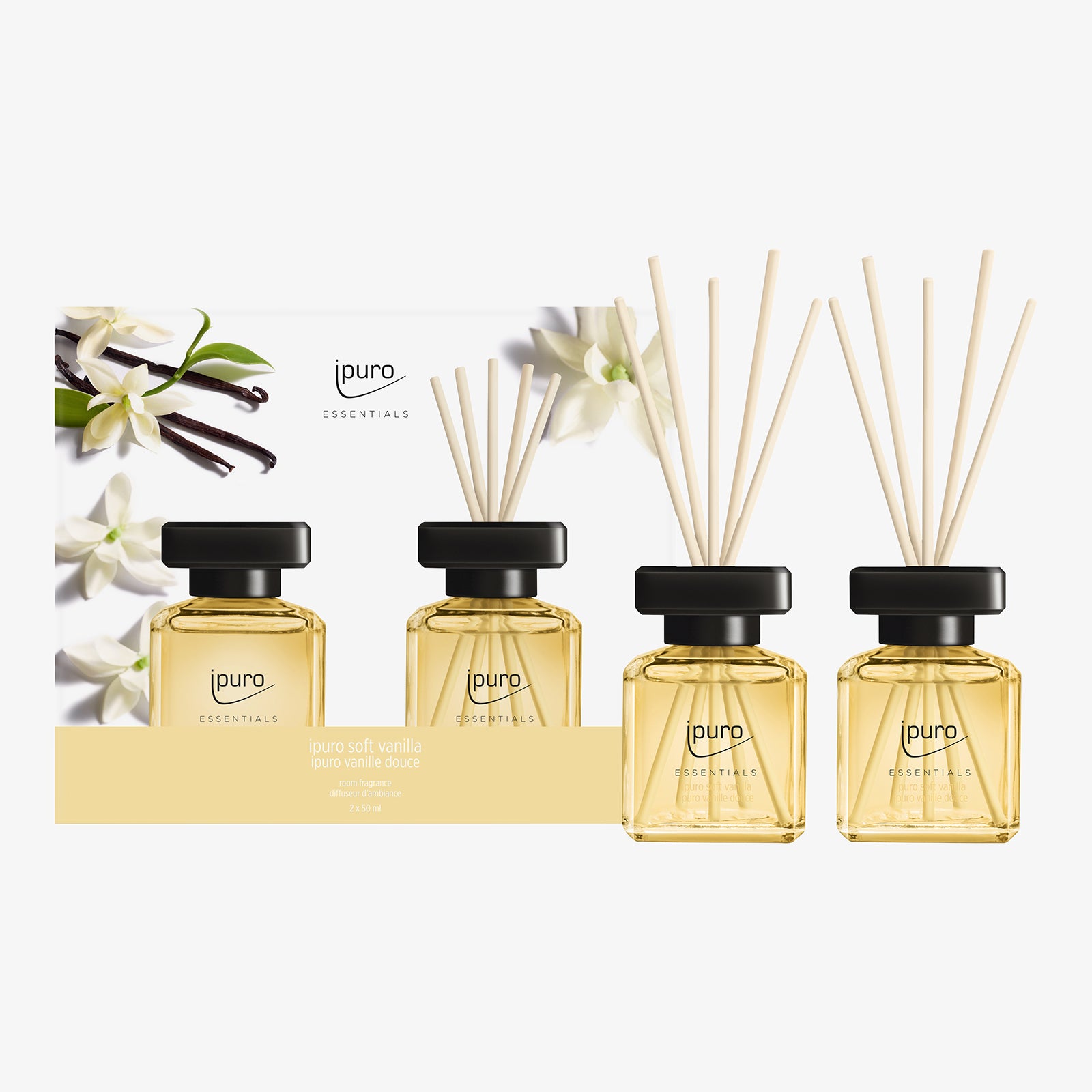 Drei Glasdüfte mit hellgelber Flüssigkeit, schwarzen Kappen und Holzschilf sind vor einer mit Vanilleblüten verzierten Schachtel abgebildet. Auf dem Etikett steht ipuro ESSENTIALS soft vanilla Raumduft-Set von ipuro mit Noten von Vanille und Sandelholz.