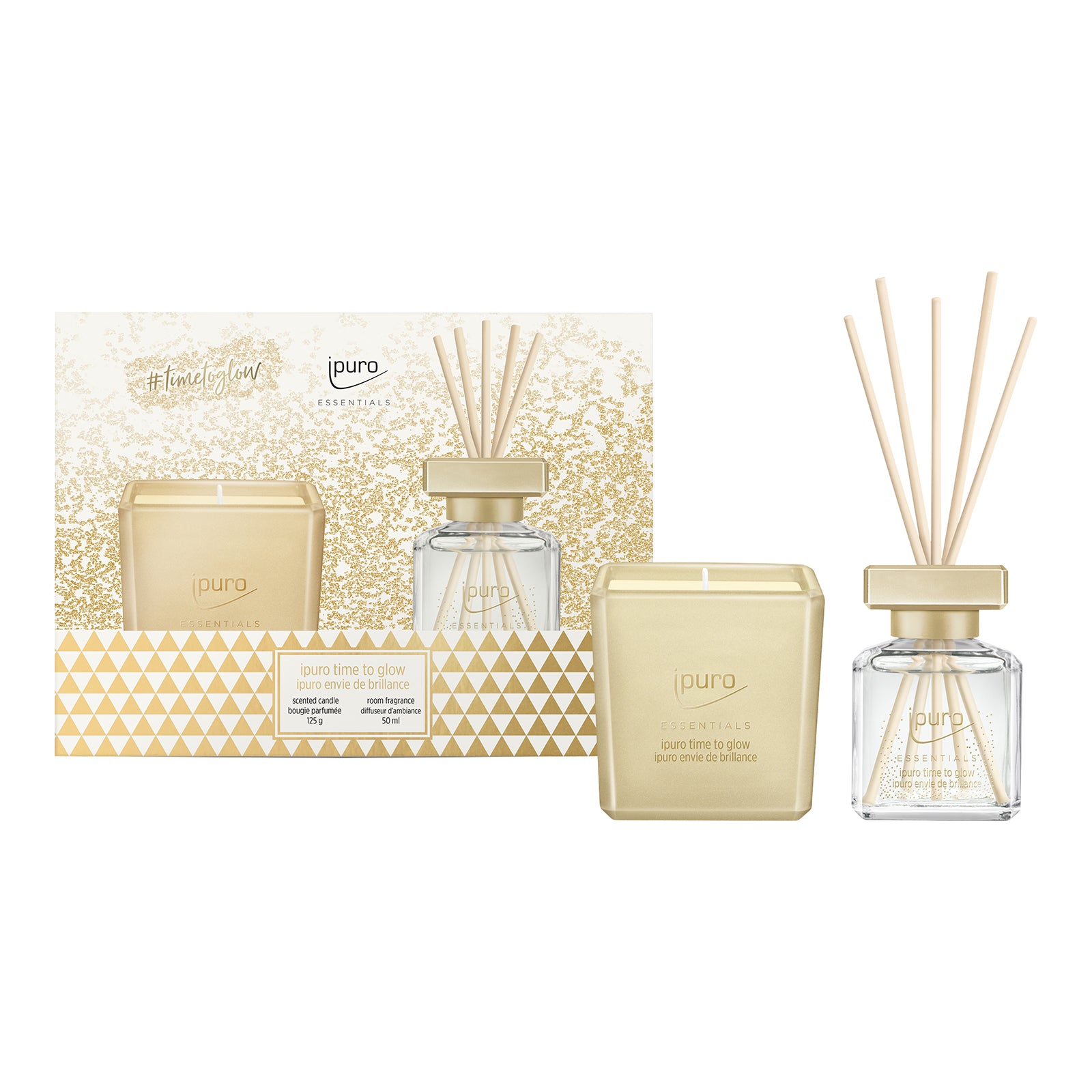 Das ESSENTIALS ipuro time to glow Geschenk-Set von ipuro besteht aus einer goldenen Kaschmirholz & Tonkabohne-Duftkerze und einem klaren Glasdiffusor, beide mit geometrischem Design in Gold und Weiß, verpackt in einer Box mit Glitzer und dem ipuro-Logo.