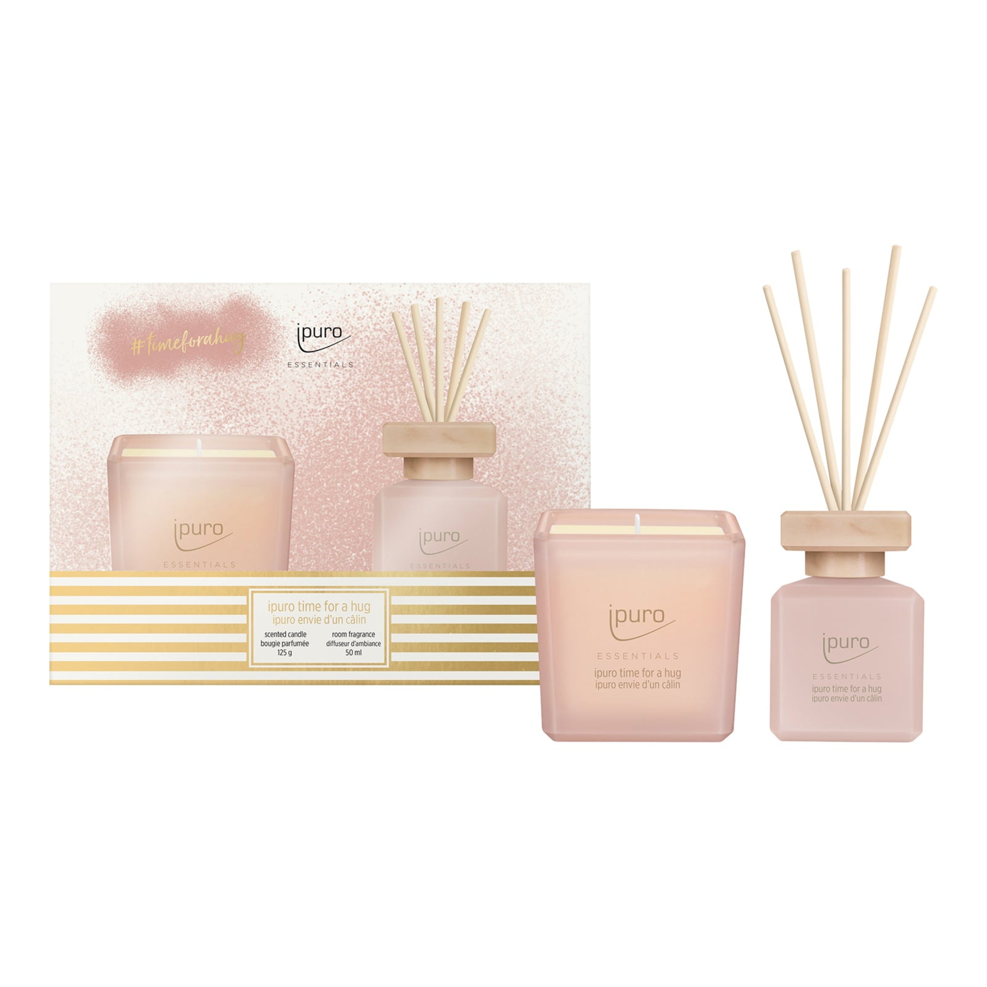 Das ipuro ESSENTIALS time for a hug Geschenk-Set besteht aus einer rosafarbenen Duftkerze und einem passenden Diffusor mit Holzstäbchen in einer eleganten, gold- und rosafarbenen Verpackung, die einen gemütlichen Duft von Vanillekeksen und roten Beeren verströmen.