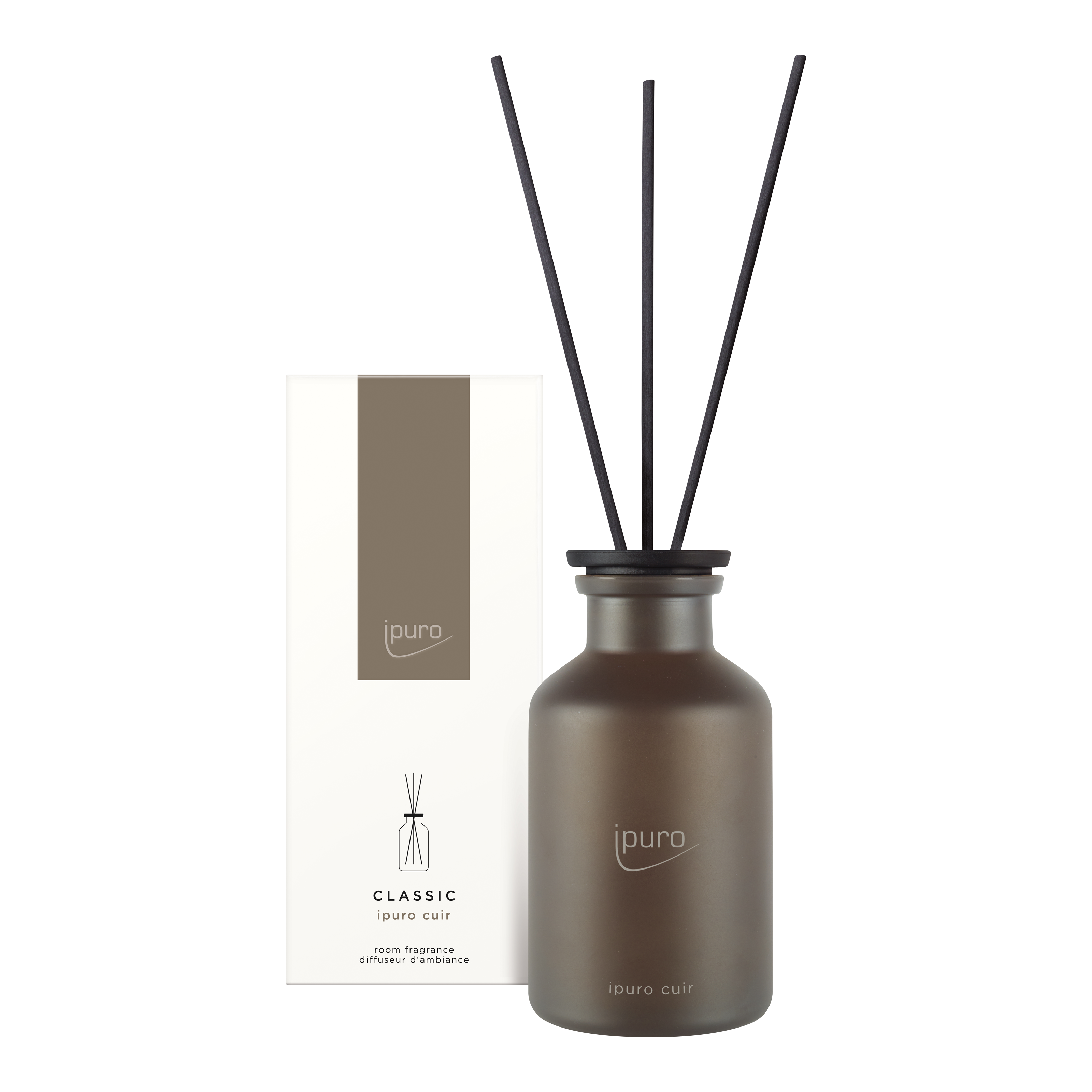 Ein brauner Milchglasdiffusor mit drei schwarzen Schilfrohren steht neben einer weiß-braunen Schachtel mit der Aufschrift ipuro CLASSIC ipuro cuir Raumduft und verströmt einen eleganten Lederduft, der von dezenten Zedernholznoten unterstrichen wird.