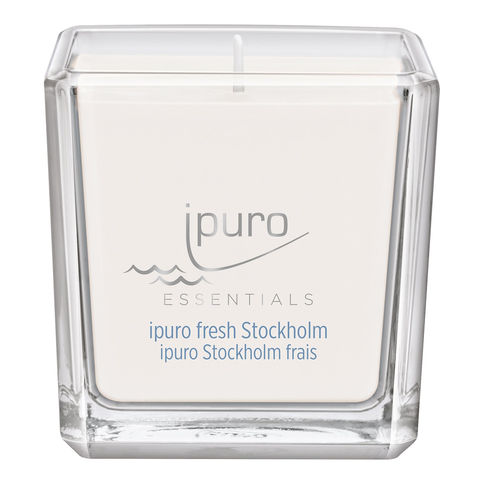 Die ESSENTIALS ipuro fresh stockholm Duftkerze von ipuro ist eine weiße Kerze mit einem Docht in einem klaren, quadratischen Glasbehälter mit grauer und blauer Beschriftung. Sie besticht durch ihr minimalistisches Design und duftet nach nordischen Leinen und frischen Meeresakkorden.