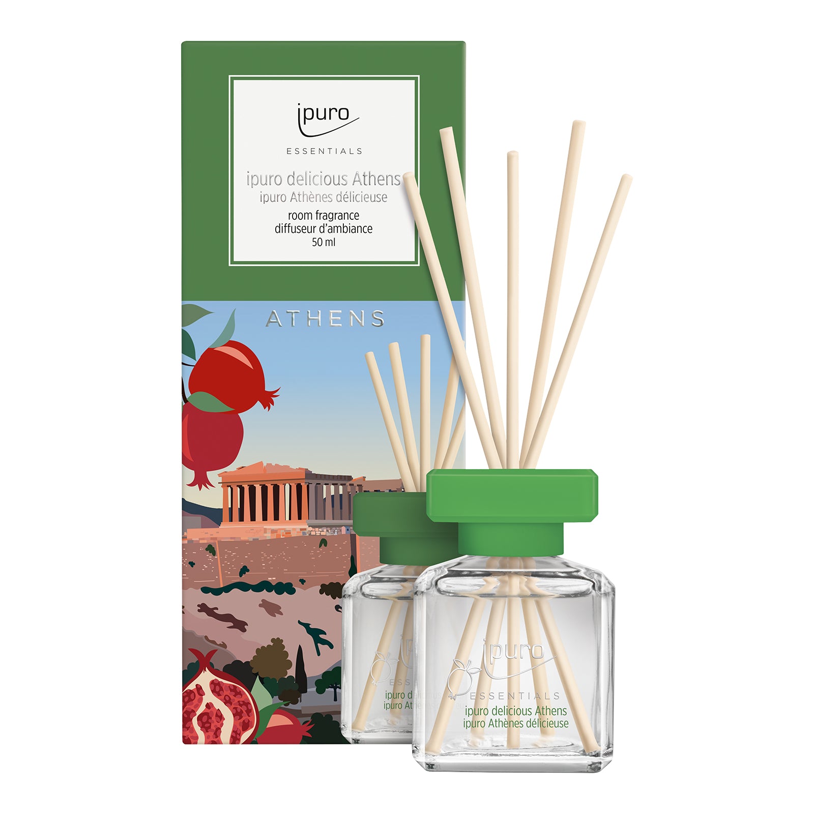 Der ESSENTIALS ipuro delicious athens Raumduft von ipuro besteht aus einem klaren Glasdiffusor mit natürlichen Schilfrohrstäbchen und grüner Kappe, der vor einer bunten Schachtel mit Granatäpfeln und dem Parthenon in Athen steht und einen erfrischenden Granatapfelduft bietet.