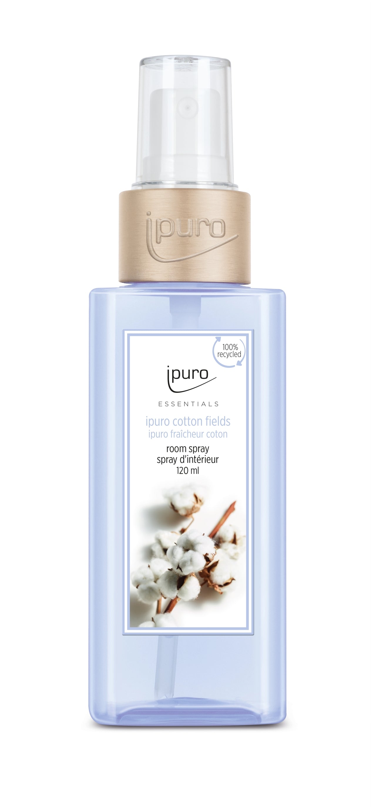 A transparent blue bottle of ESSENTIALS ipuro cotton fields Raumspray with a beige cap and spray nozzle. The label features cotton flowers and details in English and French, evoking soft Vanille notes for a comforting scent.