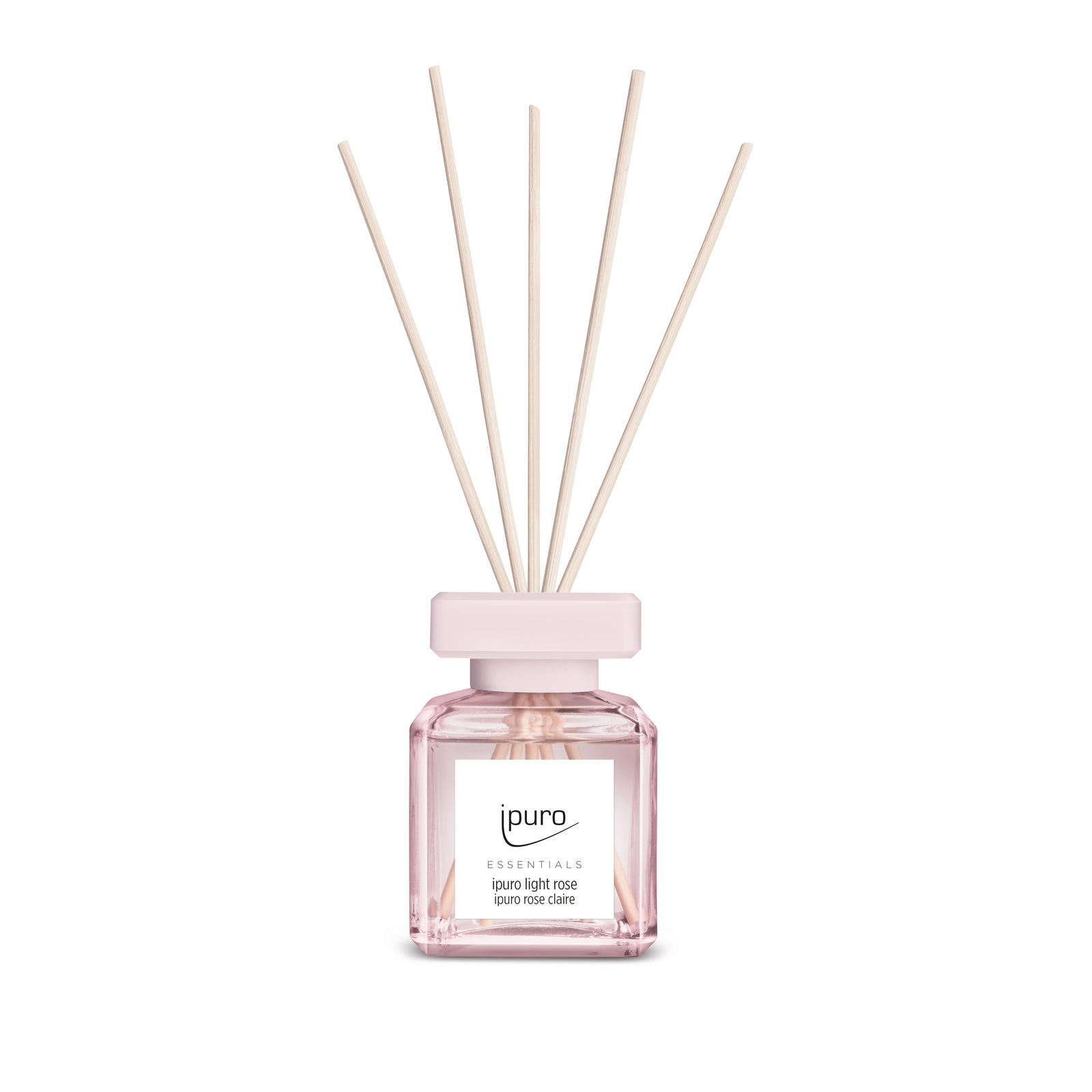 Das ESSENTIALS ipuro light rose & pure rose Raumduft-Set von ipuro besteht aus einer klaren Glasflasche mit hellrosa Flüssigkeit und naturfarbenen Diffusorstäbchen, die einen zarten Duft für Ihren Raum erzeugen.