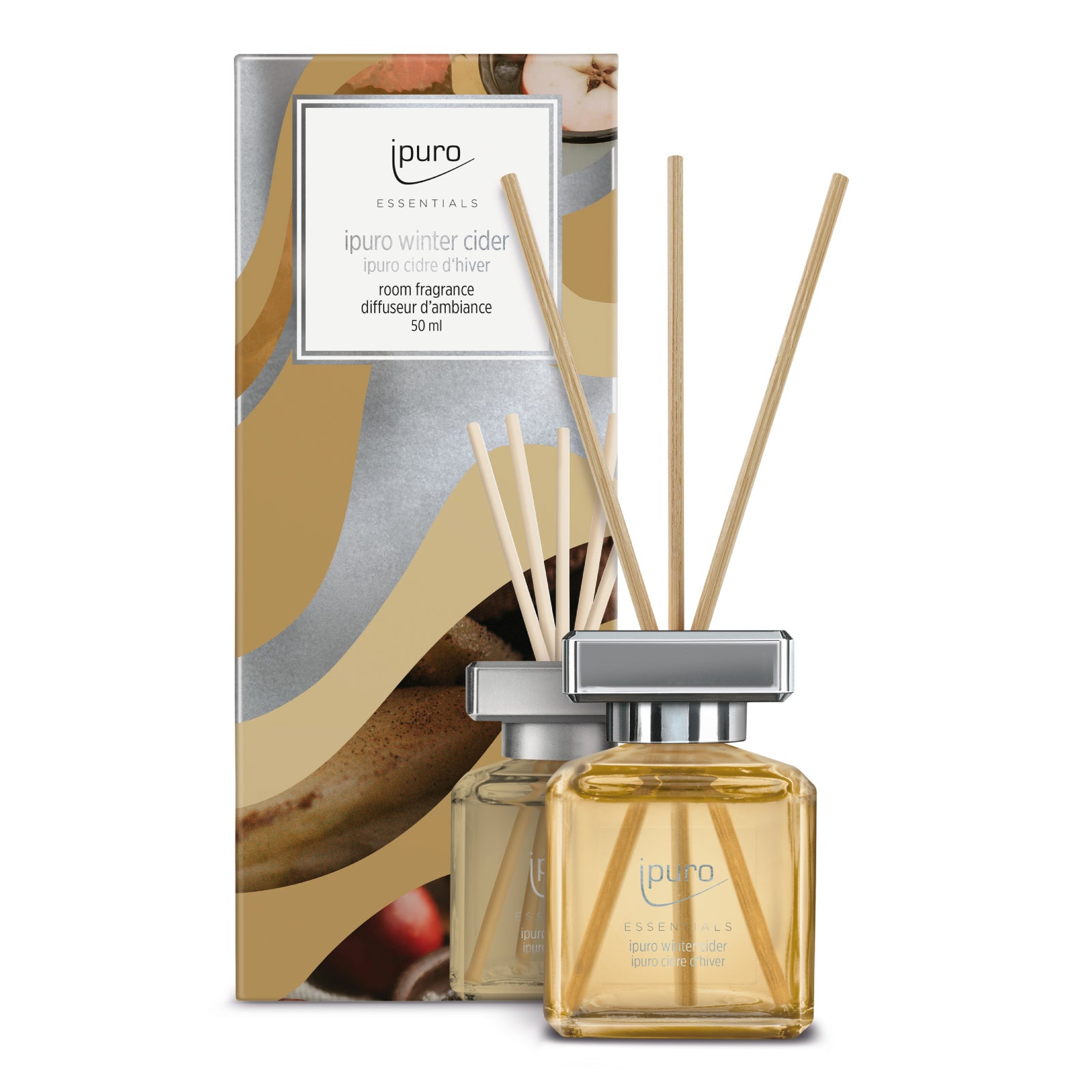 Ein Glasflakon des ipuro Essentials Winter Cider Raumduftdiffusors mit Holzblättern steht vor seiner dekorativen Schachtel mit der Aufschrift "ipuro Essentials Winter Cider".