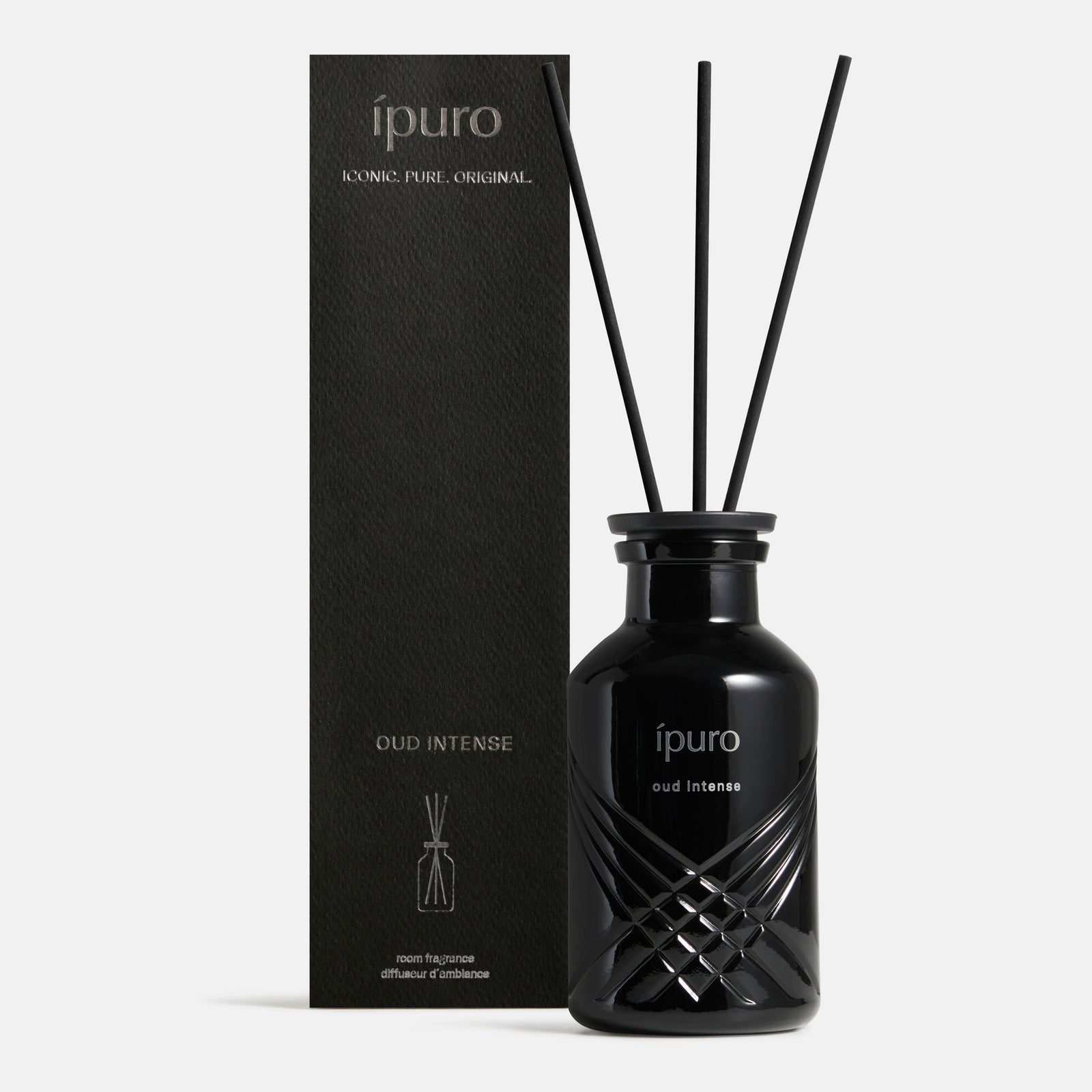 Ein schwarzer Glasdiffusor mit der Aufschrift ipuro oud intense" von ipuro mit drei schwarzen Schilfrohren steht neben einer passenden schwarzen Box - beide fangen den reichen Oud-Duft und die subtilen Safran-Noten ein.