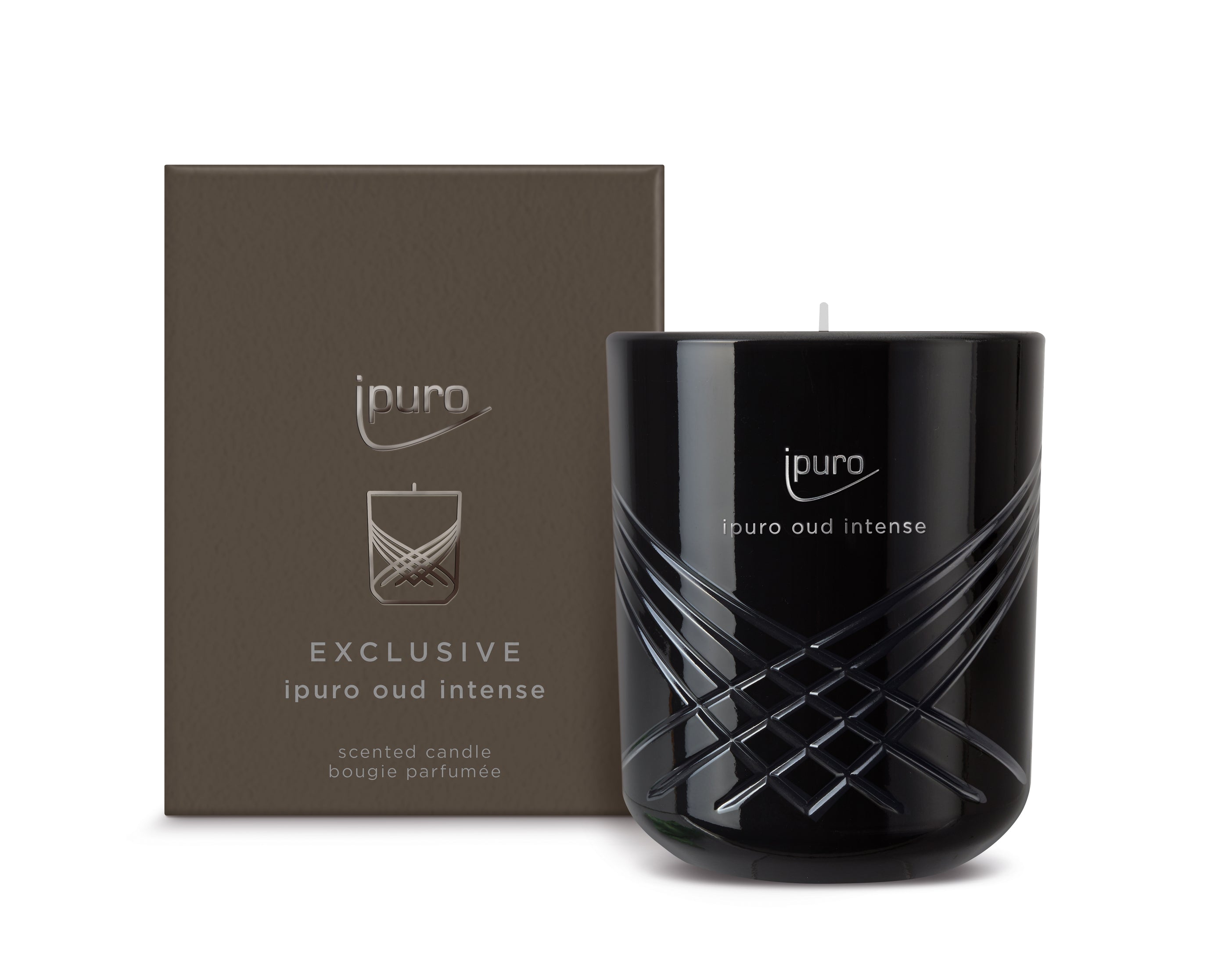 Eine schwarze Duftkerze - ipuro EXCLUSIVE ipuro oud intense Duftkerze - mit Oud- und Sandelholznoten, in einem eleganten Glashalter mit silbernen geometrischen Linien, steht vor einer passenden braunen ipuro-Box.