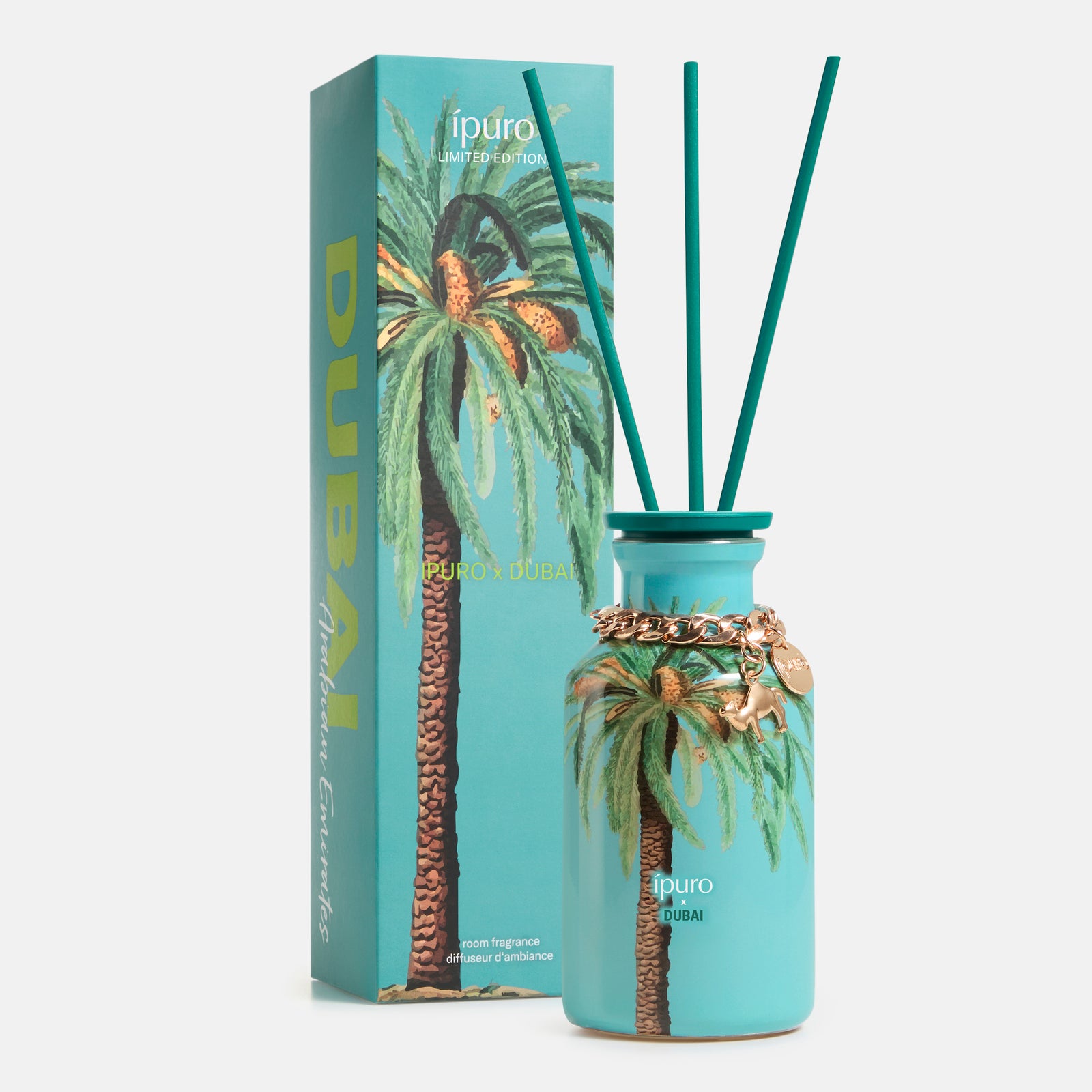 Erleben Sie Luxus mit der LIMITED EDITION ipuro x DUBAI Raumduft 240ml: ein türkisfarbener Diffusor mit goldenen Akzenten und Palmenmotiv, drei Schilfrohrstäbchen und eine passende Box. Orientalischer Duft mit Sandelholz für ein exklusives Ambiente.