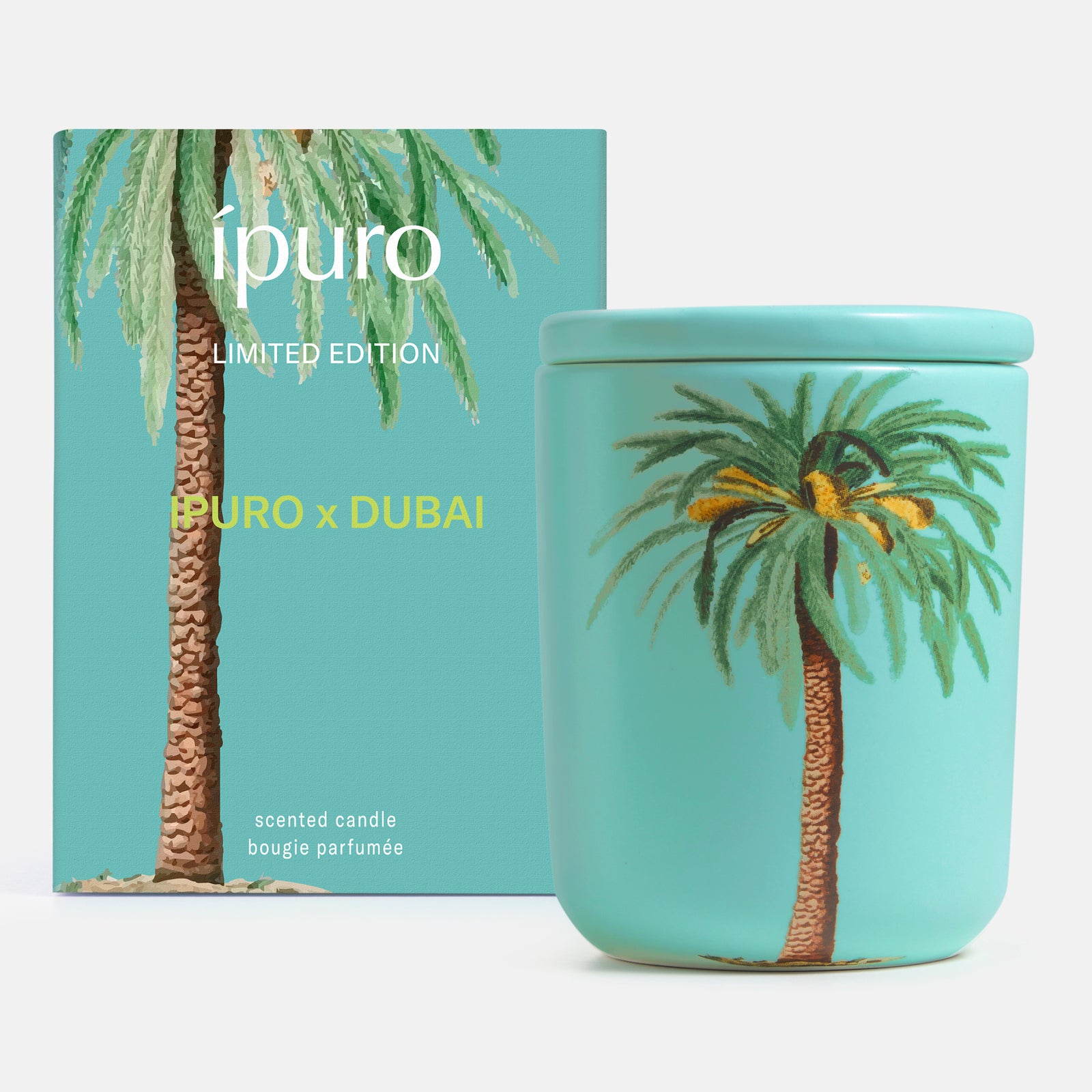 Ein türkisfarbenes ipuro x Dubai 270g-Kerzenglas und eine passende Schachtel, beide mit einer gemalten Palme versehen. Auf der Schachtel steht "ipuro LIMITED EDITION" und bietet einen Dubai-Duft mit einem Hauch von Sandelholz und orientalischem Parfüm.