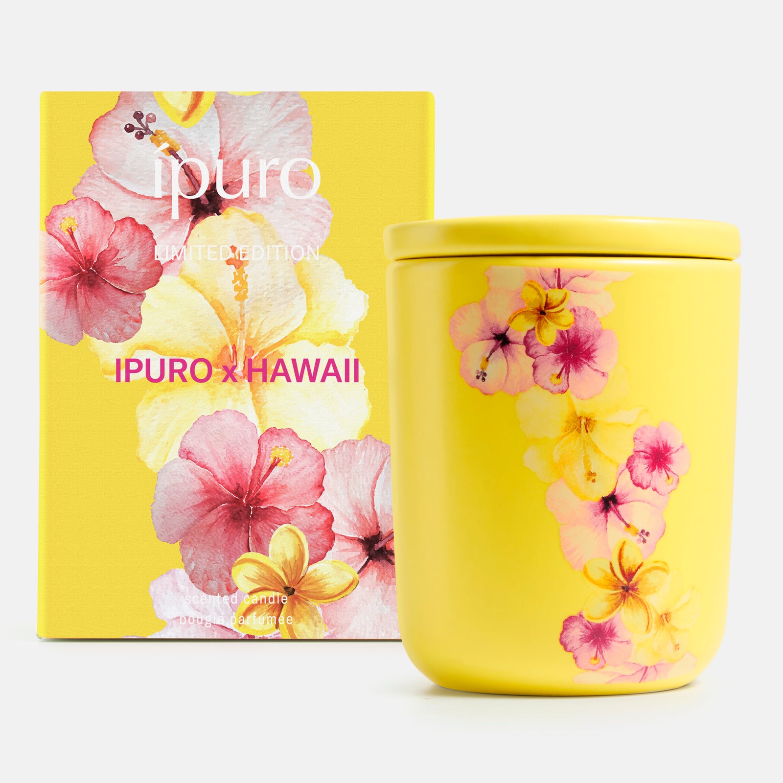 Die Duftkerze ipuro x Hawaii 270 g von ipuro wird in einem gelben Tiegel und einer gelben Schachtel geliefert, die beide mit rosa und gelben Hibiskus- und Tropenblüten verziert sind. Der weiße Schriftzug "ipuro x Hawaii" erinnert an den Duft hawaiianischer Blüten.