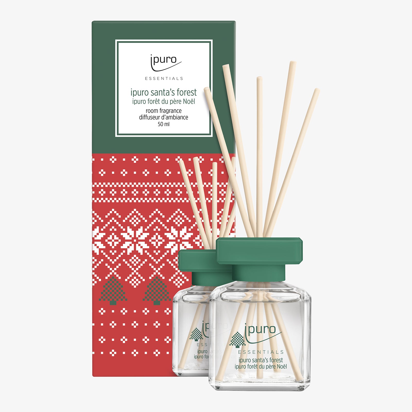 Zwei gläserne Diffusorflaschen mit grünen Deckeln und hölzernen Schilfrohren stehen vor einer festlichen roten Schachtel mit einem weißen Pullover-Muster. Auf der Schachtel steht "ipuro ESSENTIALS Raumduft santa's forest", was an gemütliche Weihnachts- und Kiefernwalddüfte erinnert.