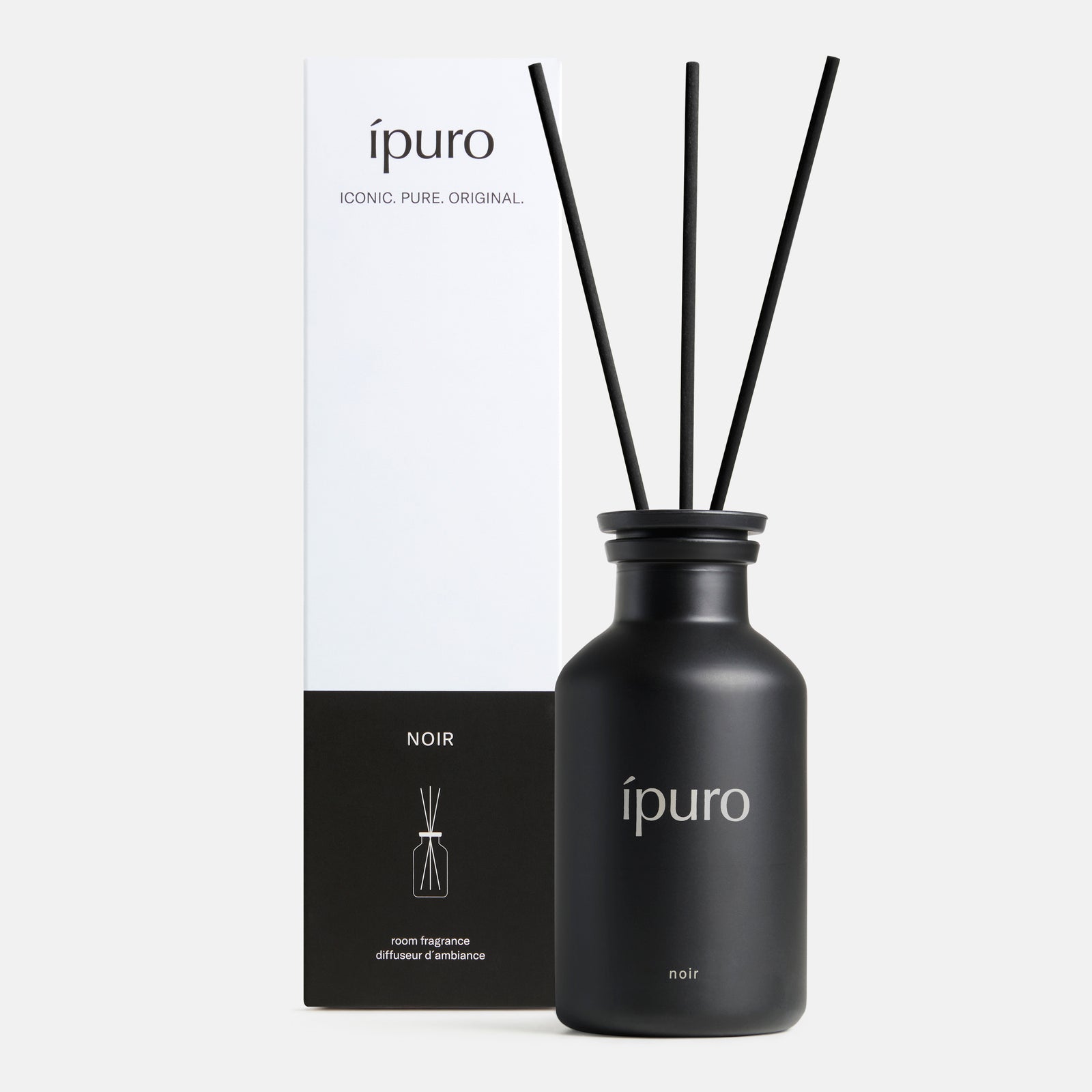 Ein schwarzer ipuro Raumduft ipuro noir Diffusor mit drei Schilfrohrstäbchen mit Sandelholz- und Rosennoten steht vor der weißen und schwarzen ipuro NOIR Verpackung.