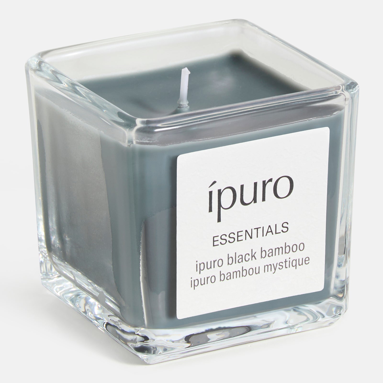 Die ipuro Duftkerze black bamboo mit dunkelgrauem Wachs in einem quadratischen Glas mit weißem Etikett verströmt einen kräuterfrischen Duft mit subtilen holzigen Noten.