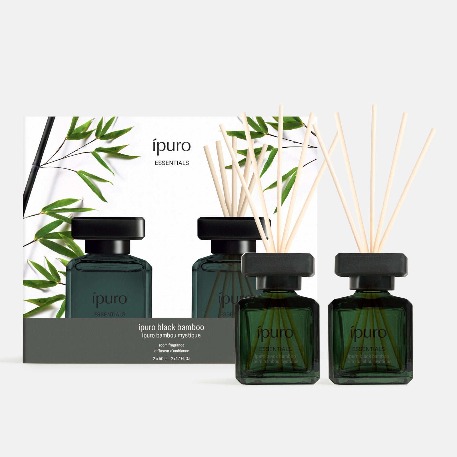 Zwei dunkelgrüne, quadratische Glasflaschen mit schwarzem Deckel und Diffusorstäbchen, beschriftet mit ipuro black bamboo, stehen vor einer passenden Schachtel mit Bambusblattgrafik. Das Raumduft-Set von ipuro bringt den frischen Duft von Bambus in Ihr Zuhause.