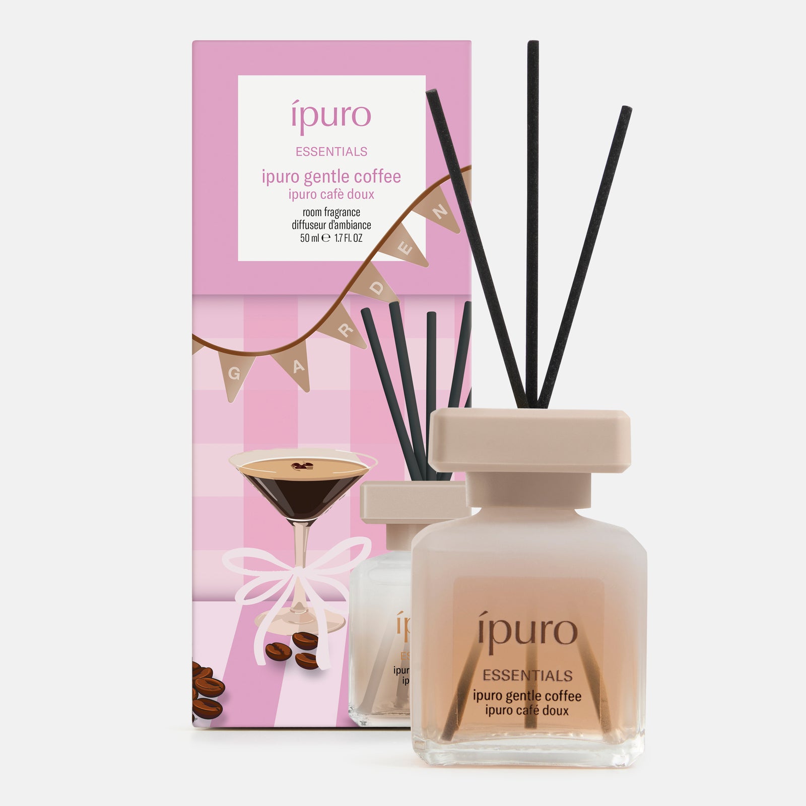 Ein Flakon des ESSENTIALS ipuro gentle coffee reed diffuser von ipuro mit schwarzem Schilfrohr steht vor seiner rosa-weißen Schachtel mit den Motiven eines Kaffee-Martinis, Kaffeebohnen, Mandel und Vanille. Beide zeigen den Produktnamen und das Volumen.