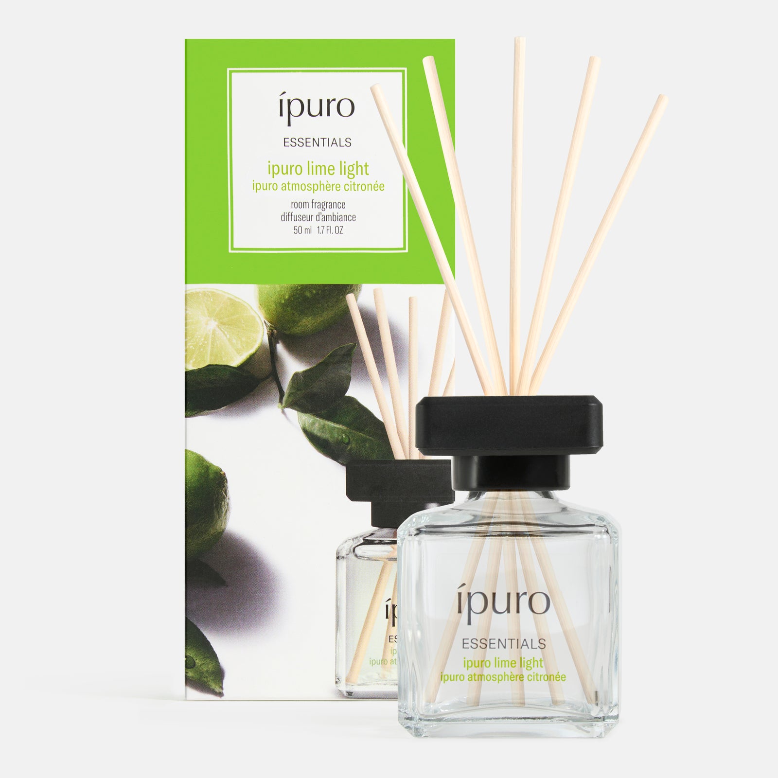 Ein klarer Glasdiffusor mit der Aufschrift ipuro lime light" von ipuro, mit schwarzem Deckel und fünf Schilfrohren, steht vor seiner grün akzentuierten Verpackung mit Limettenmotiven und erfüllt den Raum mit einem frischen Duft und einem Hauch von Zitronengras.