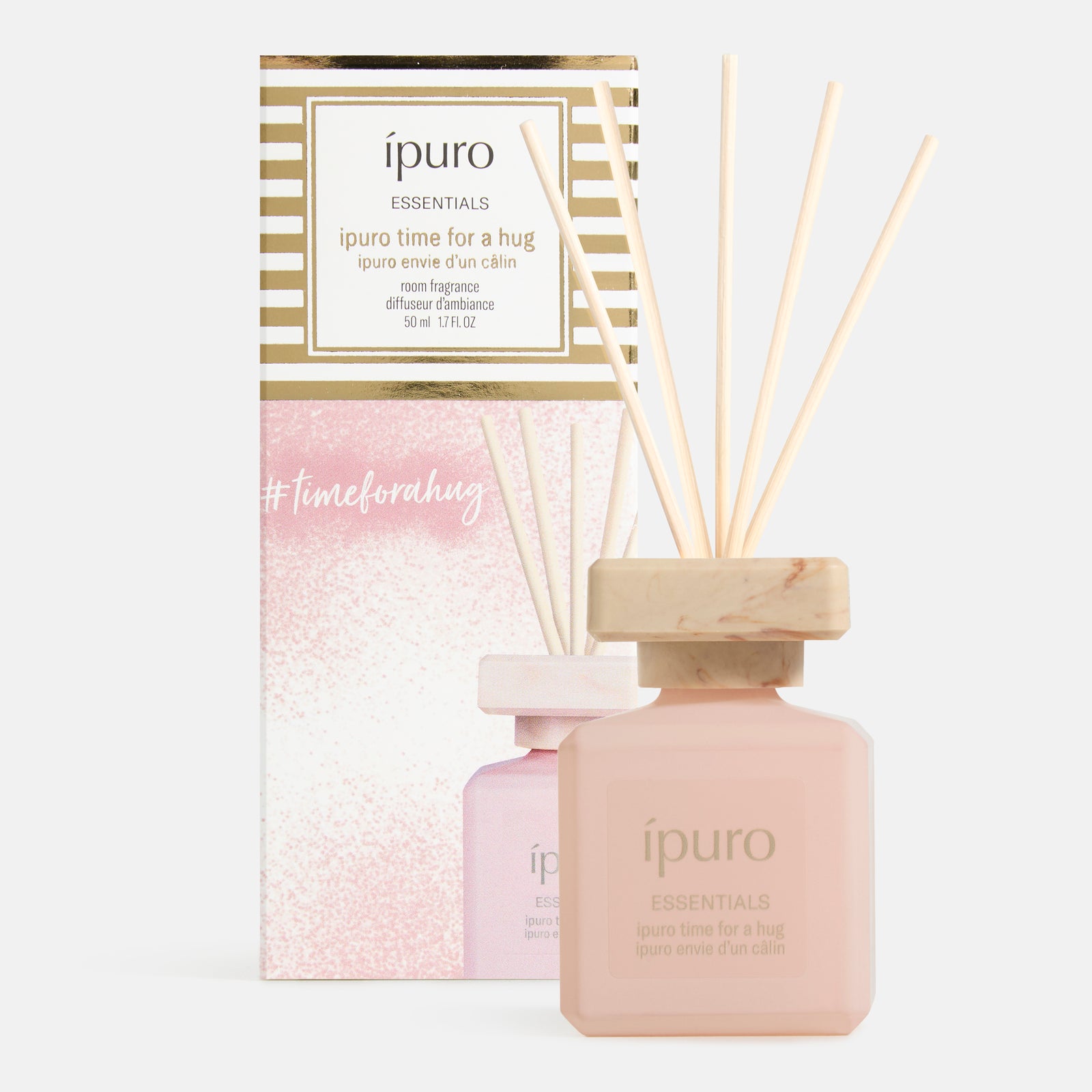 Ein rosafarbener Flakon des ipuro Raumduft "time for a hug" Rohrdiffusors mit Holzstäbchen sitzt vor seiner passenden rosa-goldenen Schachtel und verströmt einen warmen Duft von Vanillekeksen und roten Beeren. #timeforahug.