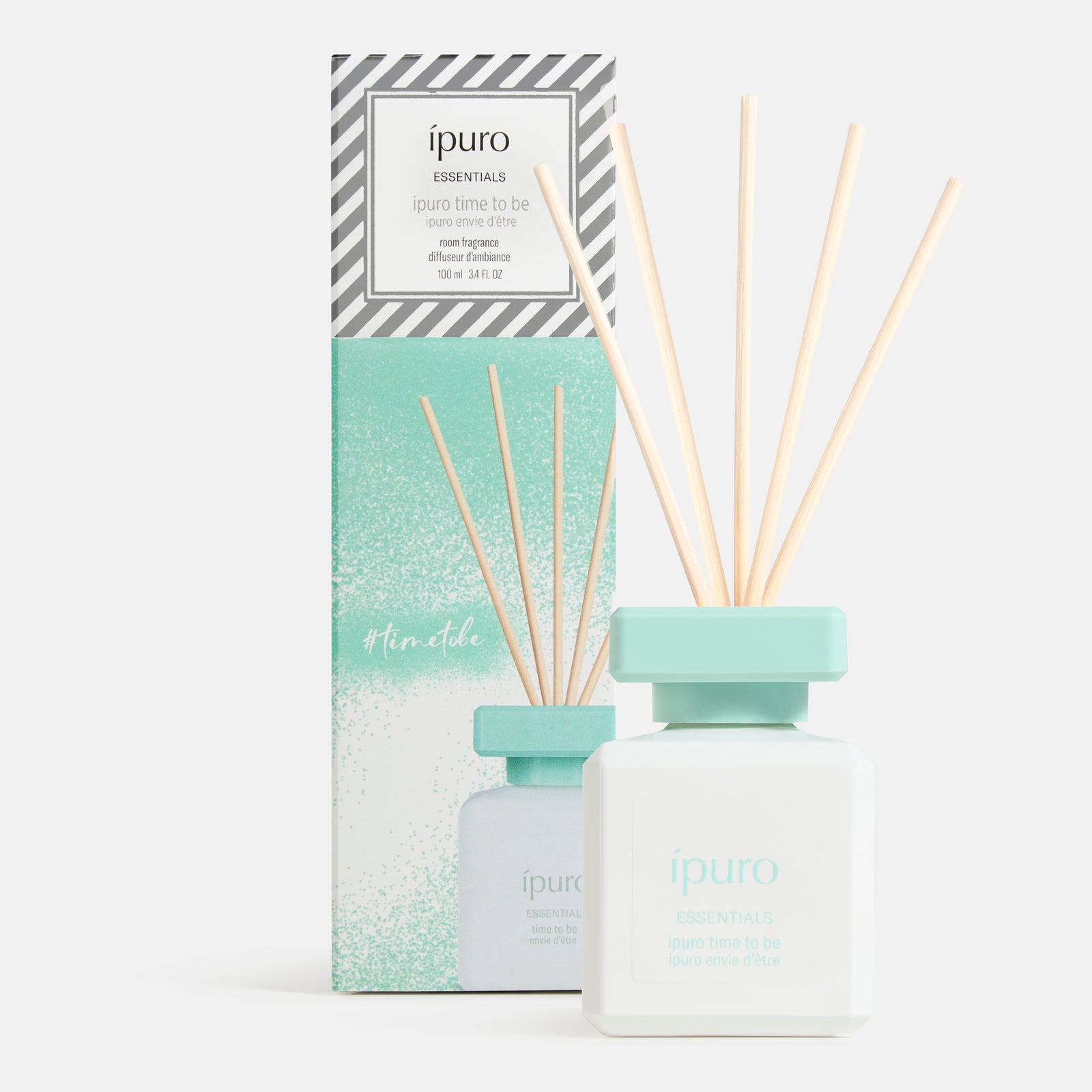 Ein moderner, weißer und mintgrüner ipuro time to be Raumduft Schilfrohrdiffusor mit fünf Stäbchen steht vor seiner passenden Box, mit einem fruchtigen Duft von ipuro - perfekt für jede Feier.