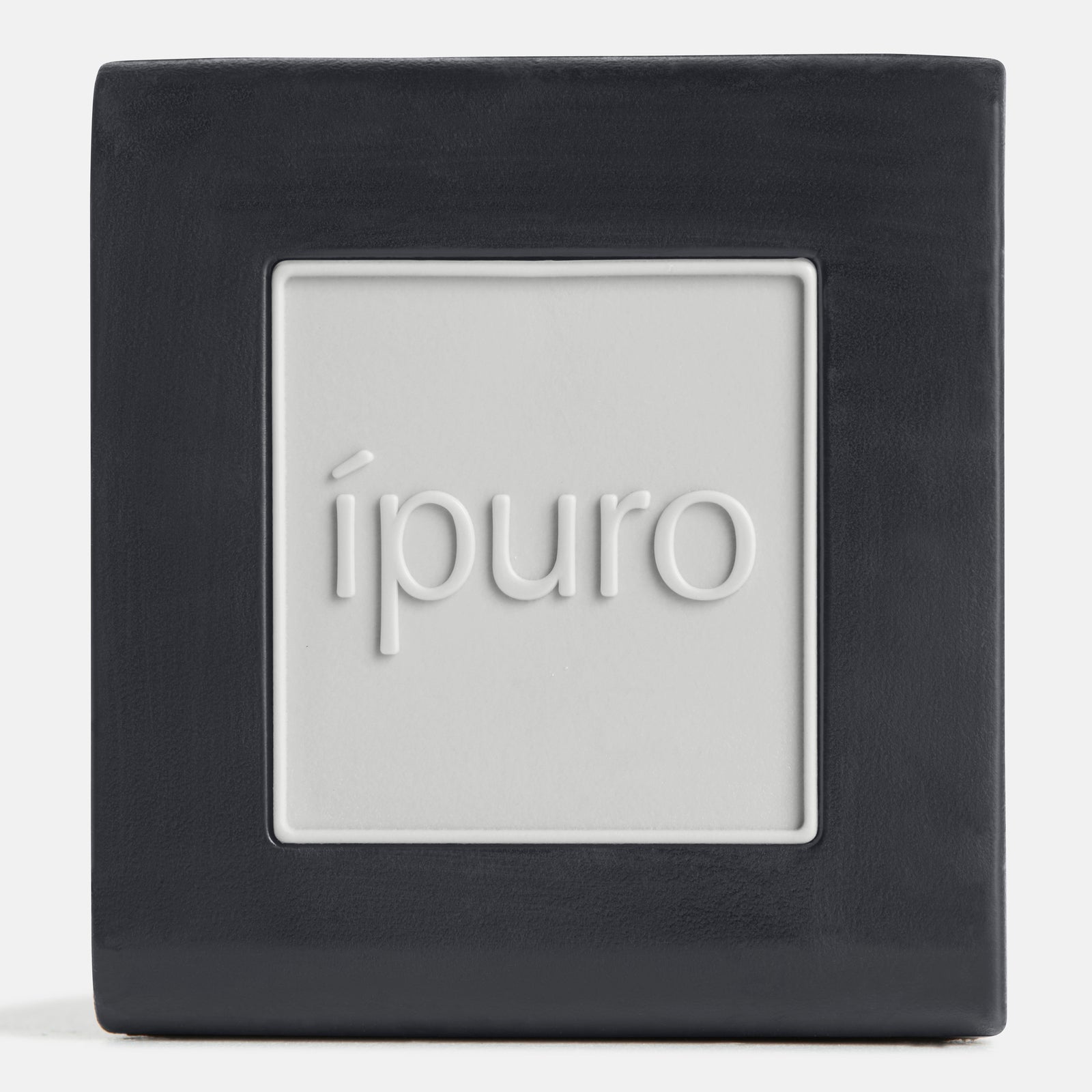 Der ipuro Autoduft weiße Lilie ist ein quadratischer schwarz-weißer Lufterfrischer mit dem eingeprägten Schriftzug "ipuro" in der Mitte, der einen subtilen Duft für ein blumiges Dufterlebnis verströmt.