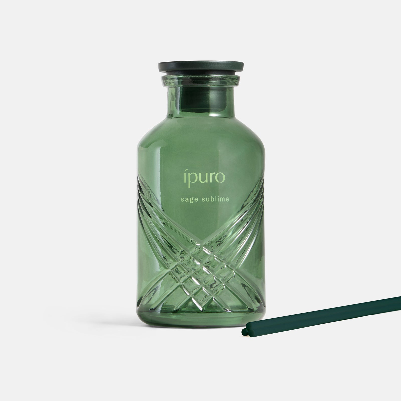 Eine grüne Glasflasche von ipuro salbei sublime Raumduft mit schwarzer Kappe und dunkelgrünem Stiel steht auf weißem Hintergrund und erinnert in ihrer sinnlichen Komposition an Salbei und mineralische Noten.