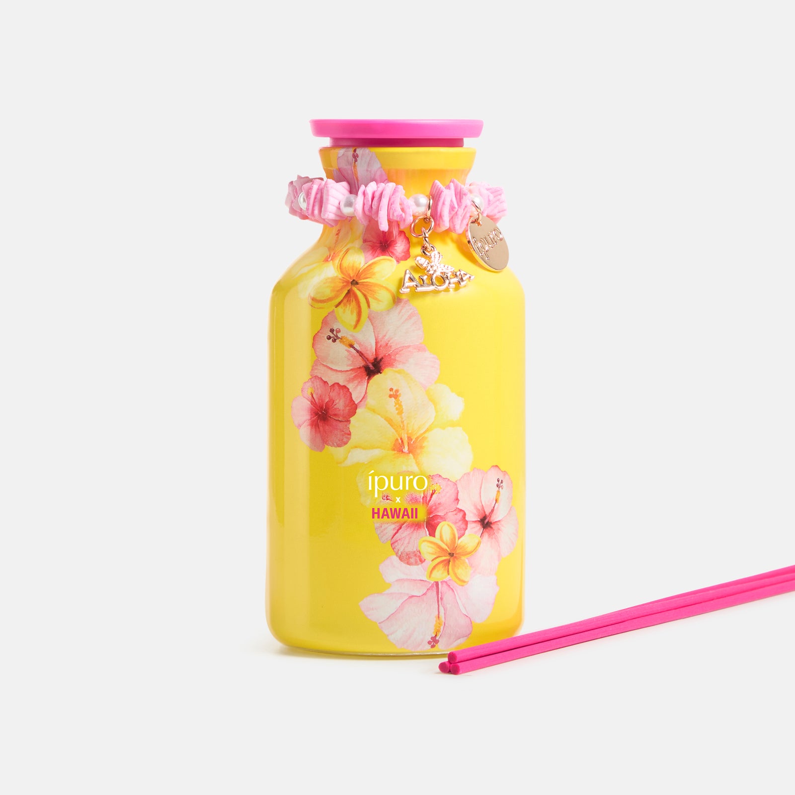 Der LIMITED EDITION ipuro x HAWAII Raumduft 240ml von ipuro kommt in einem leuchtend gelben Flakon mit pinkfarbenen und gelben Hibiskusblüten, einer pinkfarbenen Kappe, einem Blumenarmband und zwei pinkfarbenen Diffusorstäbchen und erinnert an den tropischen Duft Hawaiis.