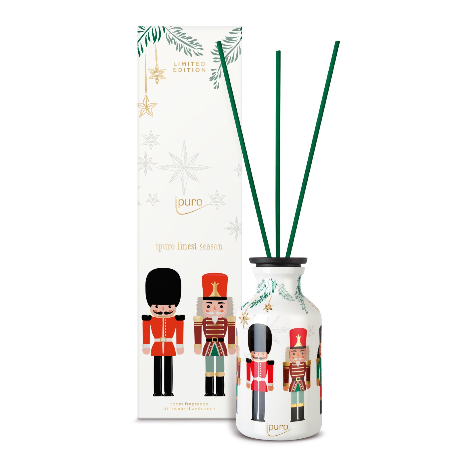 Der ipuro finest season Raumduft 240ml von ipuro besteht aus einer weißen Diffusorflasche mit grünem Schilfrohr und einem festlichen Nussknackermotiv, das zusammen mit der passenden, mit Weihnachtsmotiven verzierten Deko-Box präsentiert wird.